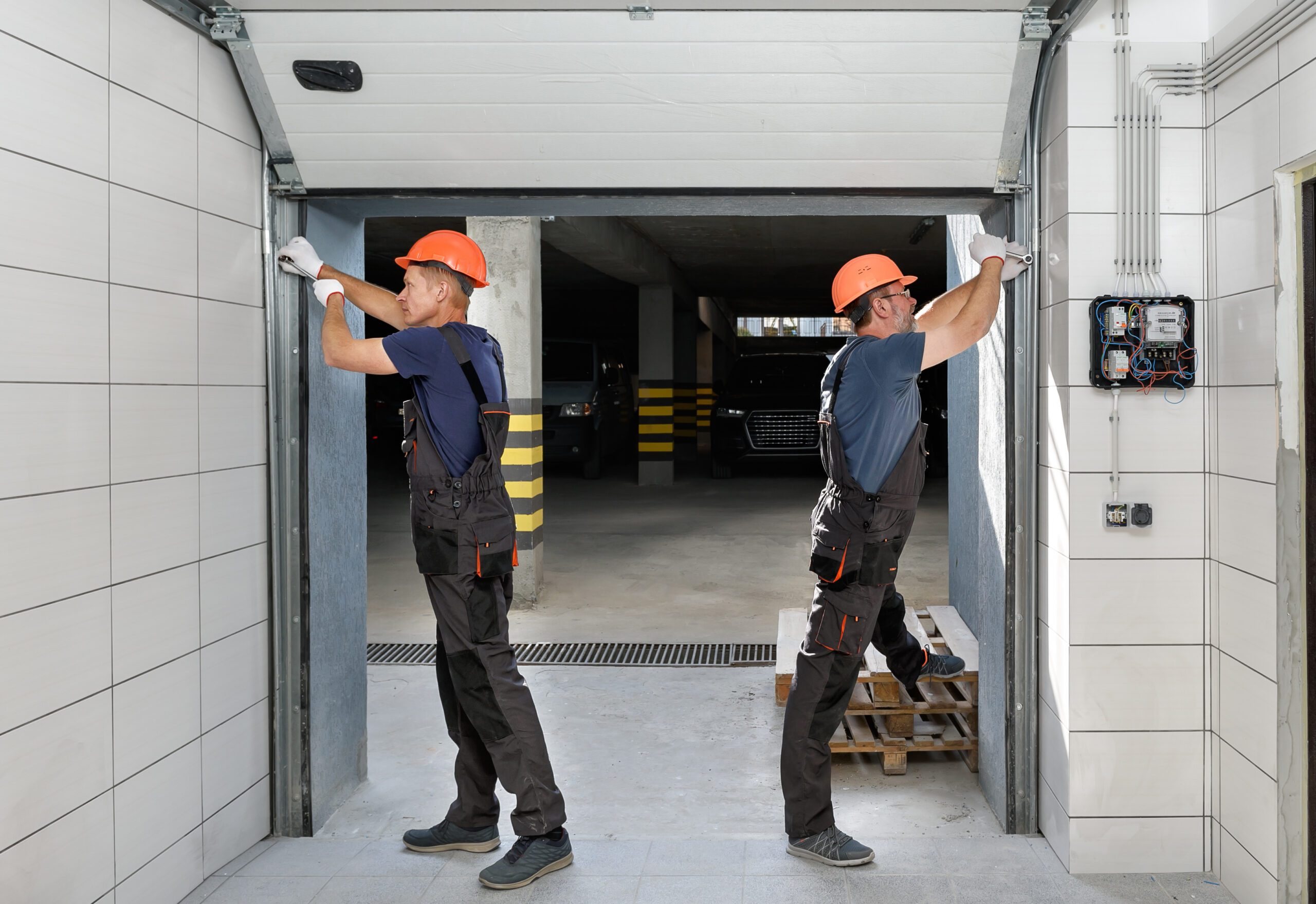 Workers from patrick sprack limited are installing lifting gates of the garage door as part of the preventive maintenance program